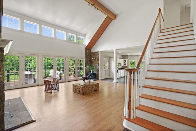 168 Sunset Hill Rd, Redding, CT 06896 - living room featuring a towering ceiling, decorative columns, stairs, and wood finished floors