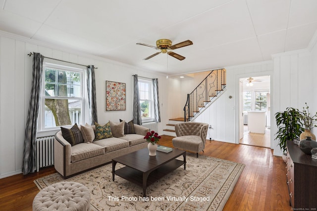 9 Fairfield Ave, Danbury, CT 06810 - living room featuring radiator heating unit, ceiling fan, wood-type flooring, stairway, and crown molding