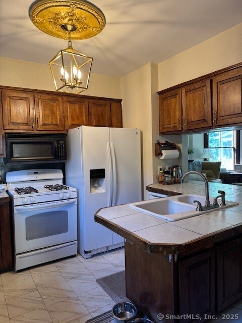240 Walnut St, Windham, CT 06226 - kitchen with white appliances, tile counters, a chandelier, and decorative light fixtures