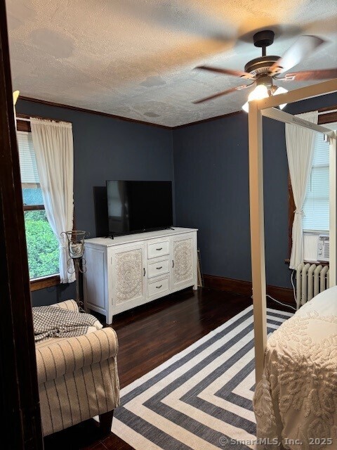 240 Walnut St, Windham, CT 06226 - bedroom featuring a textured ceiling, dark wood-type flooring, radiator, and ceiling fan