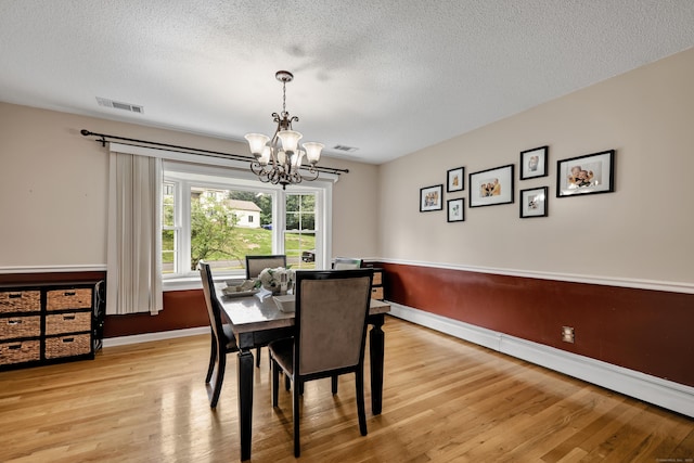 114 Tiffany Ln, Bristol, CT 06010 - dining room with a chandelier, a textured ceiling, light wood-style floors, and a baseboard heating unit