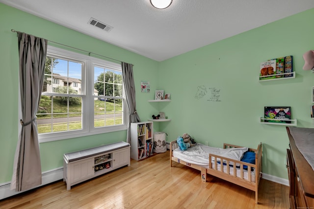 114 Tiffany Ln, Bristol, CT 06010 - bedroom with light wood-type flooring and a baseboard heating unit