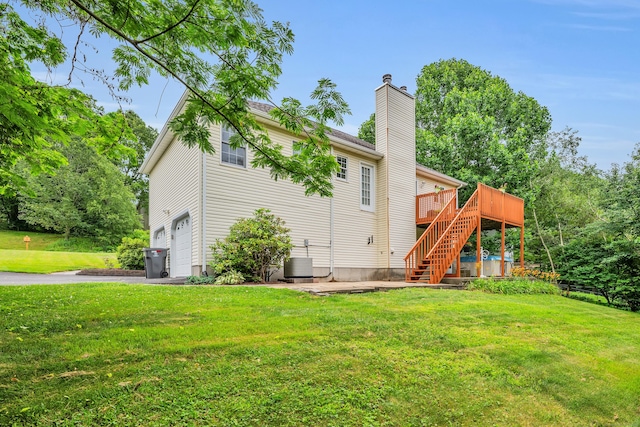 114 Tiffany Ln, Bristol, CT 06010 - rear view of property with stairs, a garage, a wooden deck, and a lawn