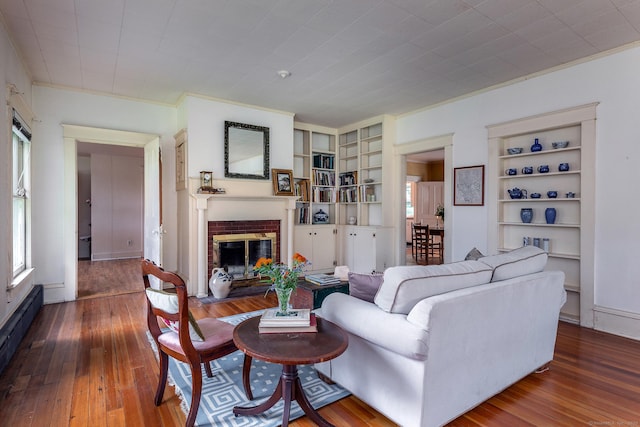 240 Main St, Salisbury, CT 06068 - living area featuring baseboard heating, a fireplace, built in features, hardwood / wood-style flooring, and crown molding