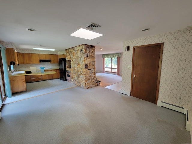 62 Rice Rd, Meriden, CT 06450 - unfurnished living room with wallpapered walls, baseboard heating, a skylight, and light carpet