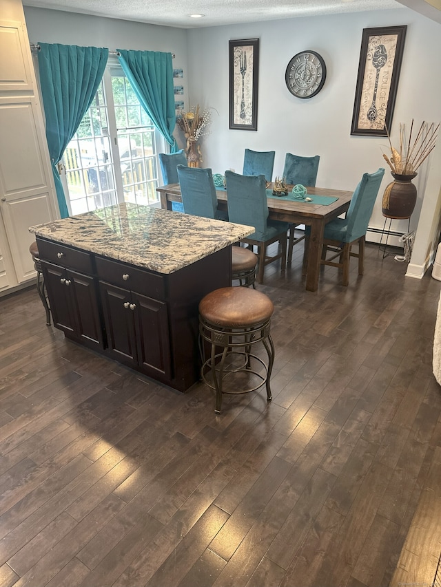 35 Depauw Cir E, Hartford, CT 06108 - kitchen with baseboard heating, dark wood finished floors, a kitchen breakfast bar, and light stone countertops