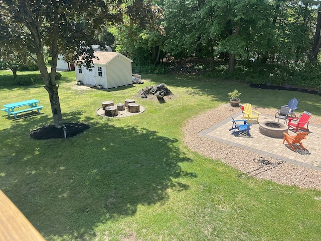 35 Depauw Cir E, Hartford, CT 06108 - view of green lawn featuring an outdoor fire pit, a patio area, and an outdoor structure