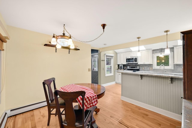 11 Harrington Rd, East Windsor, CT 06016 - dining area featuring light wood-style flooring, plenty of natural light, and baseboard heating