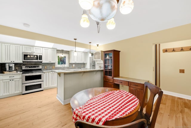 11 Harrington Rd, East Windsor, CT 06016 - dining room with light wood-type flooring and baseboards