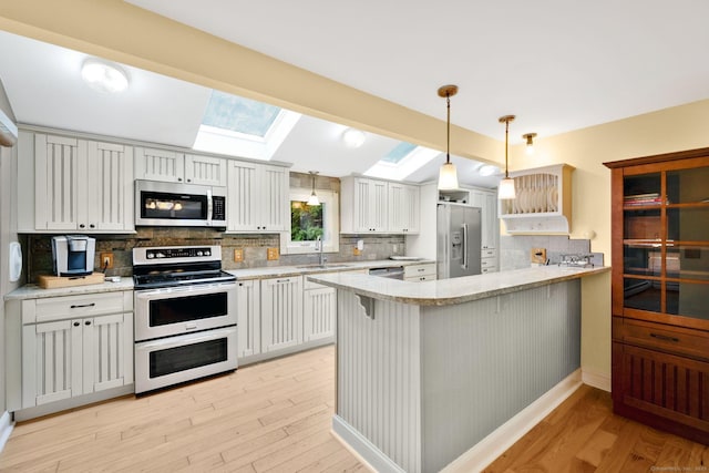 11 Harrington Rd, East Windsor, CT 06016 - kitchen with stainless steel appliances, a skylight, a peninsula, and light wood-type flooring