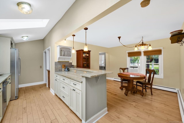 11 Harrington Rd, East Windsor, CT 06016 - kitchen featuring freestanding refrigerator, a peninsula, light wood-style floors, white cabinetry, and tasteful backsplash