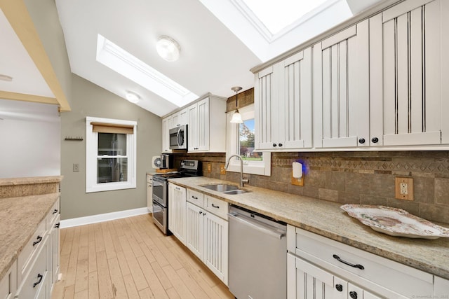 11 Harrington Rd, East Windsor, CT 06016 - kitchen with appliances with stainless steel finishes, backsplash, a skylight, lofted ceiling, and light stone countertops