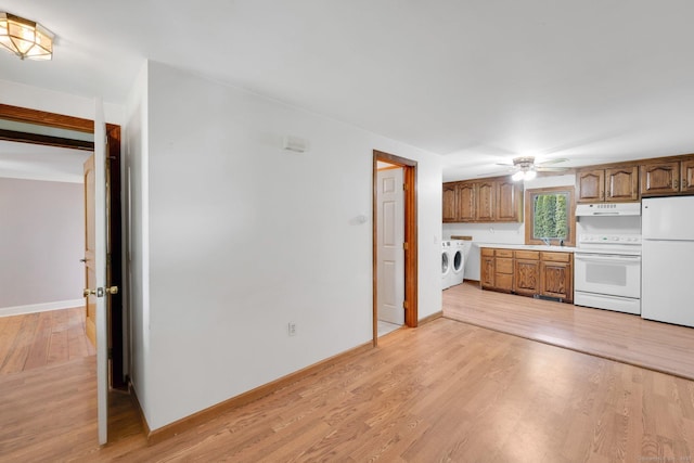 11 Harrington Rd, East Windsor, CT 06016 - kitchen with white appliances, under cabinet range hood, separate washer and dryer, light wood-style floors, and light countertops