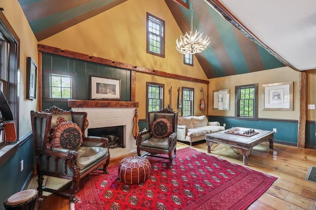 12 Jackson Rd, Killingworth, CT 06419 - living room featuring healthy amount of natural light, a chandelier, hardwood / wood-style flooring, a fireplace, and high vaulted ceiling