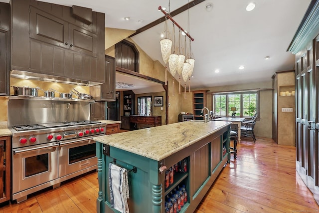 12 Jackson Rd, Killingworth, CT 06419 - kitchen featuring lofted ceiling, an island with sink, light wood-type flooring, range with two ovens, and open shelves