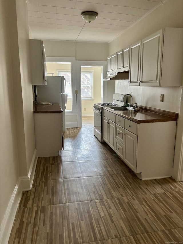 1483 Boston Ave, Bridgeport, CT 06610 - kitchen featuring white range with gas stovetop, dark countertops, under cabinet range hood, and dark wood finished floors