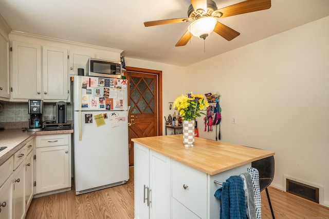 145 Quaker Ln S, West Hartford, CT 06119 - kitchen featuring freestanding refrigerator, light wood-style floors, stainless steel microwave, wood counters, and white cabinets