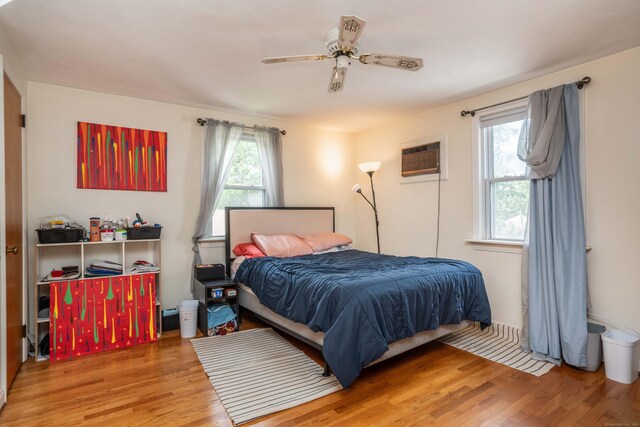 145 Quaker Ln S, West Hartford, CT 06119 - bedroom with wood finished floors, a wall mounted air conditioner, and a ceiling fan