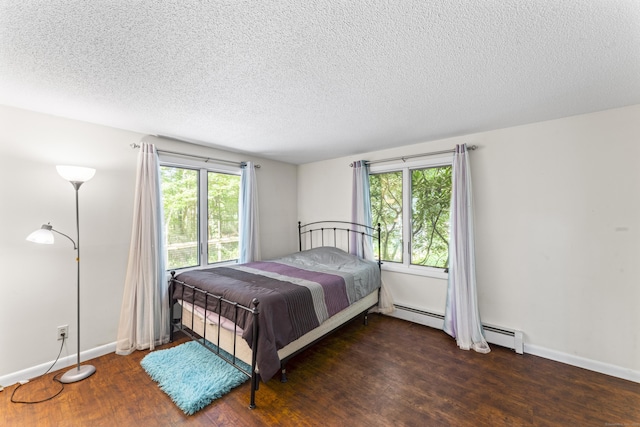 30 W Woods Rd, Burlington, CT 06013 - bedroom featuring wood finished floors, multiple windows, a textured ceiling, and a baseboard heating unit