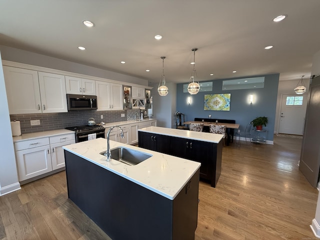 22 Thorson Rd, Oxford, CT 06478 - kitchen with an island with sink, appliances with stainless steel finishes, backsplash, white cabinets, and recessed lighting