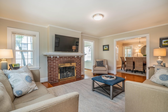 169 Brace Rd, West Hartford, CT 06107 - living area featuring ornamental molding, plenty of natural light, wood finished floors, a fireplace, and a chandelier