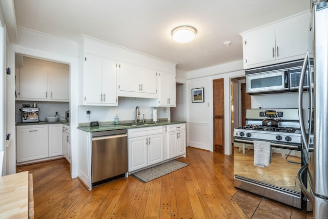 169 Brace Rd, West Hartford, CT 06107 - kitchen featuring stainless steel appliances, light wood-style flooring, white cabinets, crown molding, and dark countertops