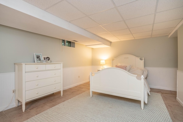169 Brace Rd, West Hartford, CT 06107 - bedroom featuring a wainscoted wall, a paneled ceiling, and light tile patterned floors