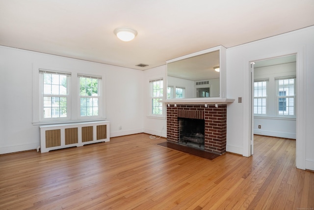 169 Brace Rd, West Hartford, CT 06107 - unfurnished living room featuring radiator, light wood-style flooring, and a fireplace