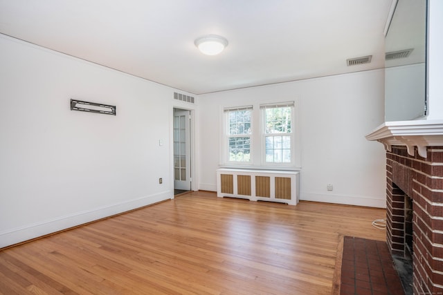 169 Brace Rd, West Hartford, CT 06107 - unfurnished living room with radiator heating unit, light wood-style floors, and a fireplace