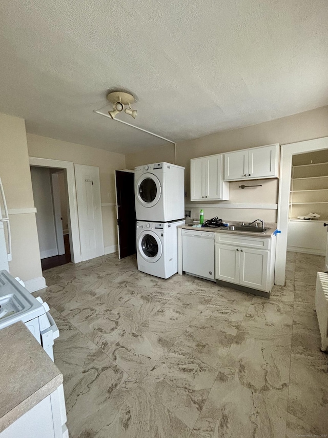 138 Mill Hill Ave, Bridgeport, CT 06610 - kitchen with stacked washer and clothes dryer, white cabinets, a textured ceiling, and white appliances
