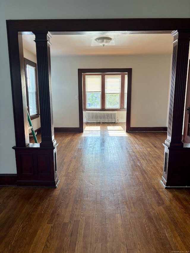 138 Mill Hill Ave, Bridgeport, CT 06610 - hallway featuring ornate columns, radiator heating unit, and dark wood-style flooring