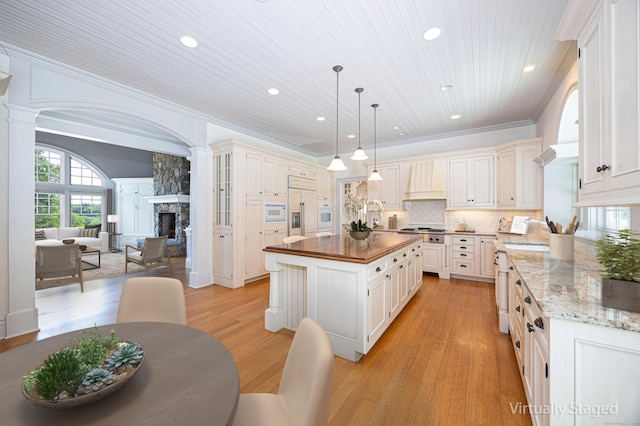 125 Nod Hill Rd, Wilton, CT 06897 - kitchen with butcher block counters, a fireplace, recessed lighting, decorative columns, and a center island
