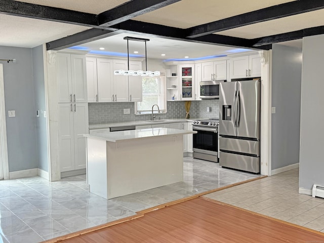 425 Scott Rd, Waterbury, CT 06705 - kitchen featuring appliances with stainless steel finishes, backsplash, light countertops, white cabinetry, and beam ceiling