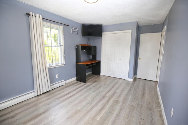 425 Scott Rd, Waterbury, CT 06705 - unfurnished bedroom with light wood-style flooring, a baseboard heating unit, a closet, and a textured ceiling