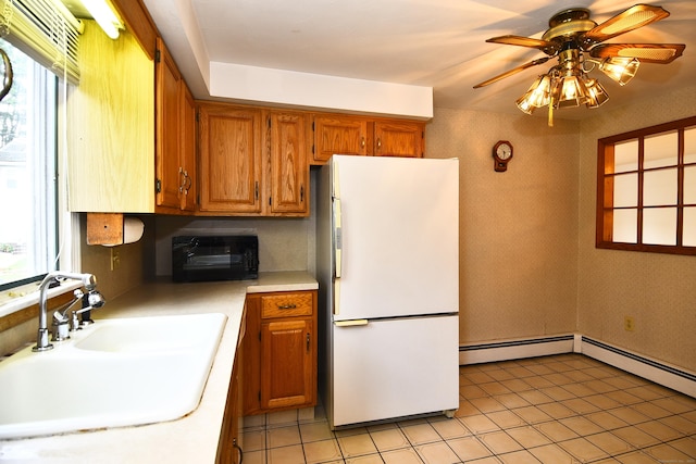 46 Millis St, Hamden, CT 06514 - kitchen featuring freestanding refrigerator, light countertops, a baseboard radiator, plenty of natural light, and wallpapered walls