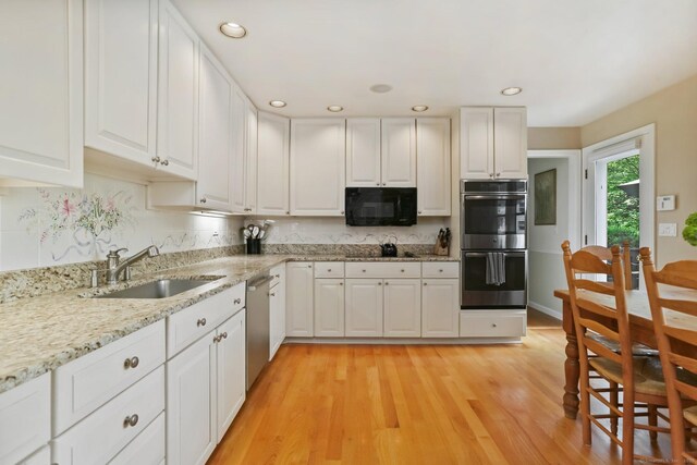 78 Kings Hwy S, Westport, CT 06880 - kitchen featuring black appliances, white cabinets, light wood finished floors, light stone countertops, and recessed lighting