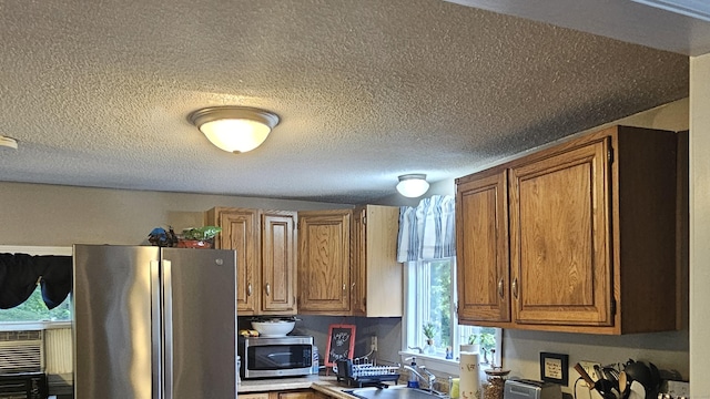 33 Tanner Ave, Norwich, CT 06360 - kitchen featuring appliances with stainless steel finishes, brown cabinets, and a textured ceiling
