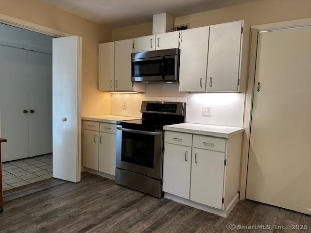 4 Heritage Crst Unit A, Southbury, CT 06488 - kitchen featuring stainless steel appliances, light countertops, dark wood-style floors, and white cabinetry