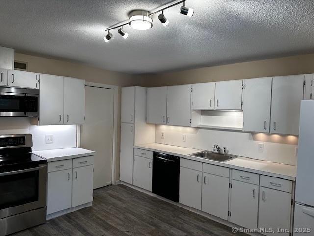 4 Heritage Crst Unit A, Southbury, CT 06488 - kitchen featuring stainless steel appliances, dark wood-style floors, light countertops, a textured ceiling, and rail lighting