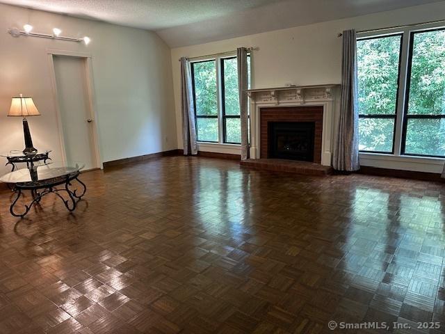 4 Heritage Crst Unit A, Southbury, CT 06488 - unfurnished living room with a brick fireplace and vaulted ceiling