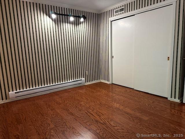 4 Heritage Crst Unit A, Southbury, CT 06488 - unfurnished room featuring baseboard heating, wood finished floors, crown molding, and wallpapered walls