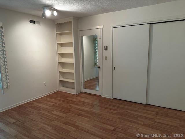 4 Heritage Crst Unit A, Southbury, CT 06488 - unfurnished bedroom featuring wood finished floors and a textured ceiling