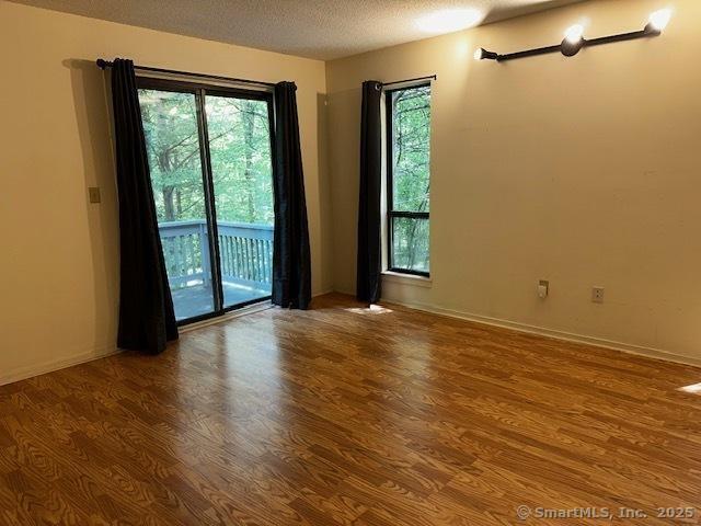 4 Heritage Crst Unit A, Southbury, CT 06488 - unfurnished room with wood finished floors, healthy amount of natural light, and a textured ceiling