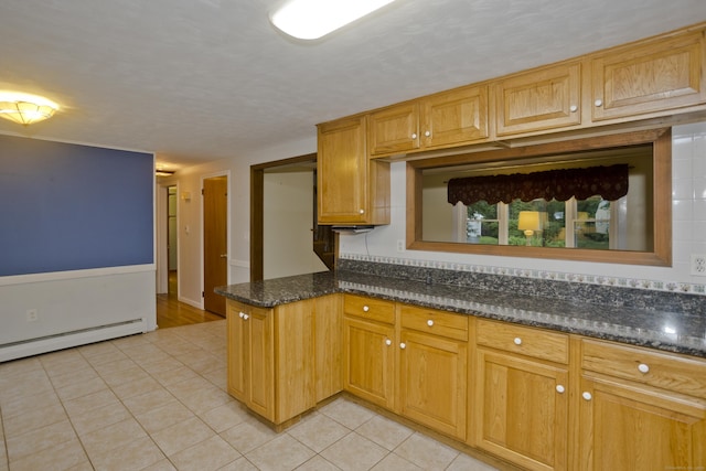 4 Birchwood Ter, Enfield, CT 06082 - kitchen with light tile patterned floors, dark stone counters, a peninsula, and baseboard heating