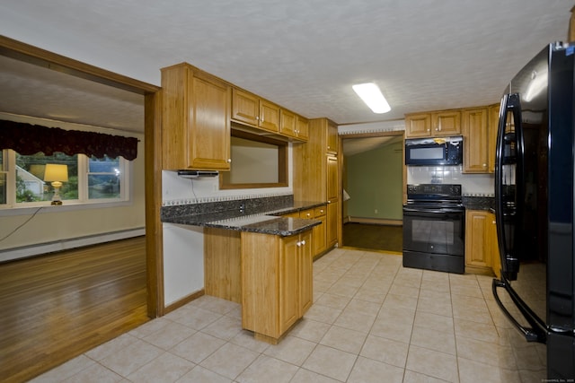 4 Birchwood Ter, Enfield, CT 06082 - kitchen featuring black appliances, a peninsula, a baseboard heating unit, light tile patterned floors, and dark stone counters