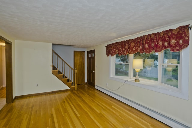 4 Birchwood Ter, Enfield, CT 06082 - empty room with baseboard heating, stairway, wood finished floors, and a textured ceiling
