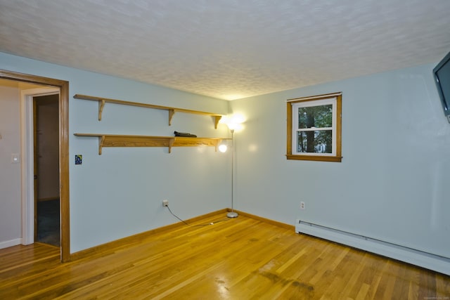 4 Birchwood Ter, Enfield, CT 06082 - empty room with baseboard heating, light wood-style floors, and a textured ceiling