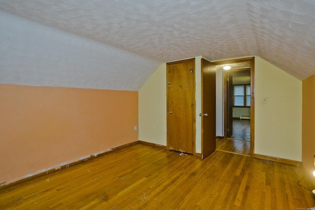 4 Birchwood Ter, Enfield, CT 06082 - bonus room featuring a textured ceiling, wood finished floors, vaulted ceiling, and baseboard heating