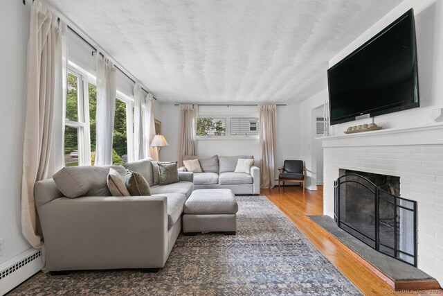 1762 Waterbury Rd, Cheshire, CT 06410 - living area with a baseboard radiator, a fireplace, and wood finished floors