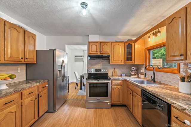 1762 Waterbury Rd, Cheshire, CT 06410 - kitchen with appliances with stainless steel finishes, under cabinet range hood, a textured ceiling, light wood finished floors, and brown cabinets